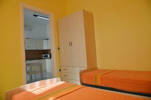 a bedroom with two beds and a cabinet and a kitchen at Mediterranea in Marina di Pescoluse +52 photos