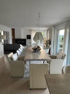 a living room with a wooden table and white chairs at Architekten-Villa, moderne 220qm, 4 Schlafzimmer, Garten in Irschenberg