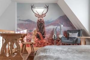 ビャウィ・ドゥナイェツにあるApartamenty TRZY IZBYの鹿の壁画が施されたベッドルーム