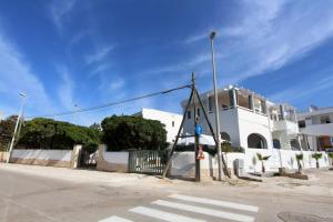 a white building with a crosswalk in front of a street at Mediterranea in Marina di Pescoluse