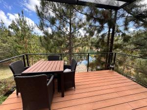 a wooden deck with a wooden table and chairs at Cozy escape, lake view in Guatapé +20 photos