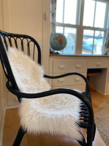 einem schwarzen Stuhl mit einem weißen pelzigen Sitz in der Unterkunft Downtown Cottage in Downtown Charlottetown in Charlottetown