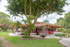 a house with a tree in front of it at Hotel El Remanso Cartago in Coloradas