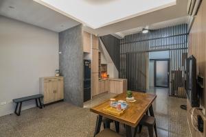 a kitchen with a wooden table in a room at Heeyaaa INN in Donggang
