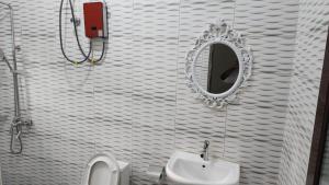a bathroom with a sink and a mirror and a toilet at Jakara Avenue Hotel- Tamale in Kyanshiogo