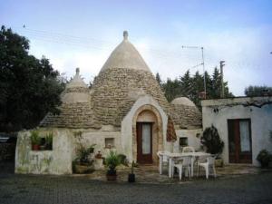 um edifício com uma mesa e cadeiras em frente em Villa Mado em Ceglie Messapica