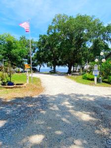 a gravel road with an american flag on a pole at Studio-Bay access-Pet friendly in Gulf Shores +4 photos