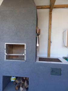 a kitchen with a blue wall with a fireplace at Casa da Tranquilidade in Barra Velha