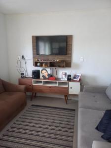 a living room with a flat screen tv on a wall at Casa da Tranquilidade in Barra Velha