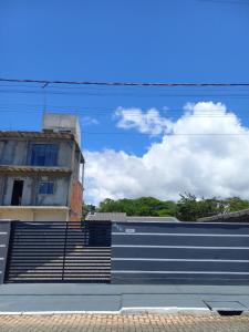 a building with a blue wall and a fence at Casa da Tranquilidade in Barra Velha