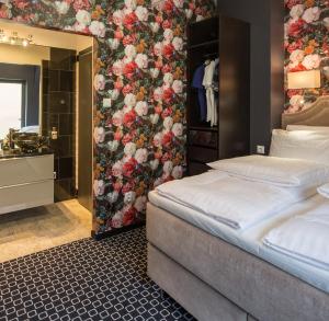 a bedroom with a bed and a floral wall at Amber Suite Szczecin hotel na Starym Mieście Adults Only in Szczecin