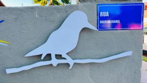 a painting of a white bird on a wall at Suítes Curió - Passarim Hospedagem in Cumuruxatiba
