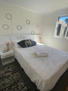 una camera da letto con un grande letto bianco con una finestra di CABAÑAS EL ZORZAL Sauce de Portezuelo a Sauce de Portezuelo