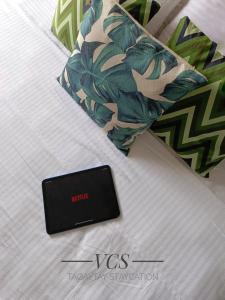 a electronic device sitting on a bed next to a pillow at VCS Tagaytay Staycation in Tagaytay +10 photos