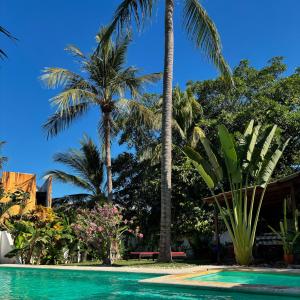 una piscina con palme sullo sfondo di Casa Bastin a Puerto Escondido