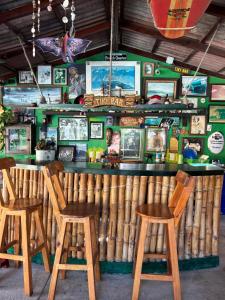 a bar with three wooden stools in a restaurant at Casa Bastin in Puerto Escondido