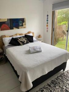 una camera da letto con un grande letto bianco con una finestra di CABAÑAS EL ZORZAL Sauce de Portezuelo a Sauce de Portezuelo