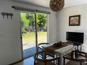 una sala da pranzo con tavolo, sedie e televisione di CABAÑAS EL ZORZAL Sauce de Portezuelo a Sauce de Portezuelo