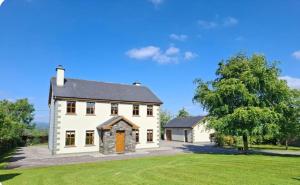 a large white house with a large yard at Meadow View in Gortatlea Junction