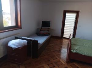 a bedroom with a bed and a window and a mirror at Casa de vacanta in Târgu Jiu