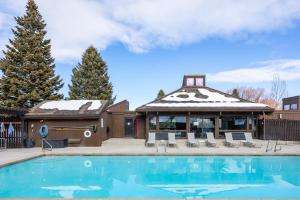 a house with a swimming pool in front of a building at Unbeatable Location, Sleeps 12, Ski Access Across the Street, Large Hot Tub, Walk to the Lift in Park City