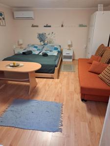 a bedroom with a bed and a table and a couch at Nagymackó Kuckója in Keszthely