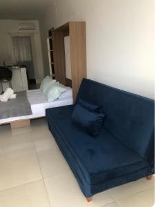 a living room with a couch and a bed at Residencial da Ju in Bombinhas