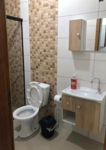 a small bathroom with a toilet and a sink at Residencial da Ju in Bombinhas +3 photos
