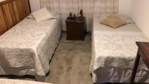 a bedroom with two beds and a night stand at Estância Paganini in Prado
