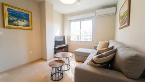 un soggiorno con un divano e un tavolo di H&H Suite Ganivet Center a Granada