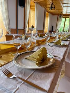 un lungo tavolo con piatti e bicchieri da vino di Auberge de l'Ange ad Albeuve