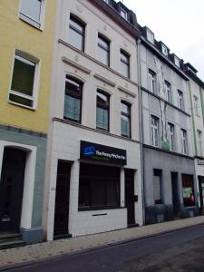 ein weißes Gebäude mit einem Schild an der Seite in der Unterkunft The Penny Pincher Inn in Köln