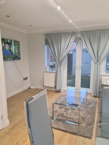 a living room with a glass table and a tv at Entire Two bedroom Rays Lodge in Middlesbrough