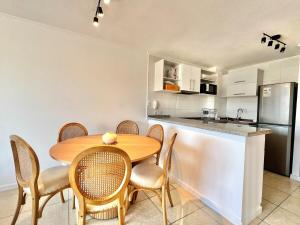 a kitchen with a wooden table and chairs and a counter at Departamento en La Herradura in Coquimbo