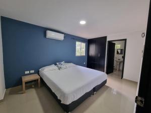 a bedroom with a blue wall and a bed at Precioso apartamento cerca playa in Ríohacha
