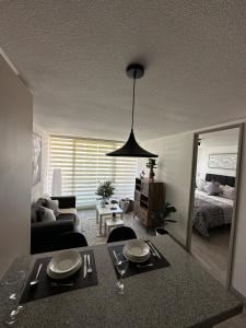 a living room with a table and a dining room at Basq Propiedades - Barrio Republica 7 in Santiago