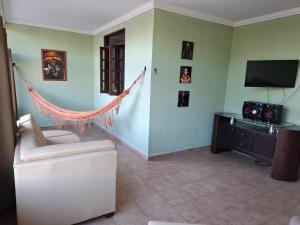 a living room with a couch and a television at Quarto Domiciliar em Antares Maceió in Maceió