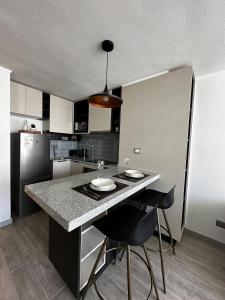 a kitchen with a island with chairs and a counter top at Basq Propiedades - Barrio Republica 7 in Santiago +26 photos