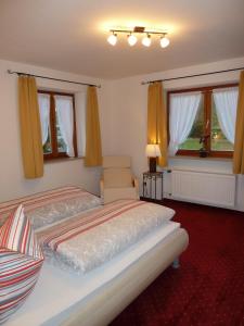 1 dormitorio con 2 camas y 2 ventanas en Haus im Kurpark, en Reit im Winkl