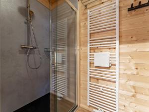 a shower in a bathroom with a wooden wall at Rattendorf 21A in Rattendorf +23 photos