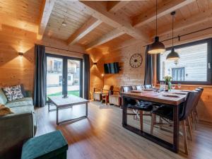 a dining room with a table and chairs and a clock at Rattendorf 21A in Rattendorf