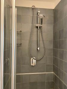a shower in a bathroom with gray tiles at Aurora House - Appartamento accogliente a Barberini in Rome +14 photos