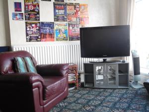 Una sala de estar con un televisor, un sofá y una silla. en Alondra Hotel, en Blackpool 71 fotos más