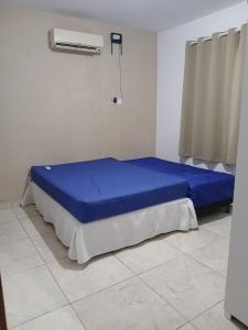 a bedroom with a blue bed in a room at Casa Jacuipe temporada in Camaçari +23 photos