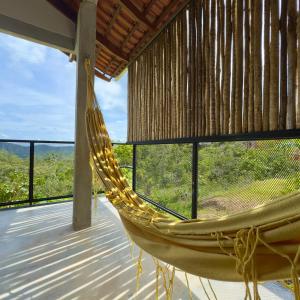 a hammock on a porch with a view at Chalés Encanto in Sao Jorge
