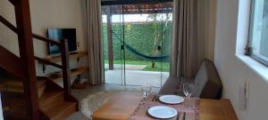 a dining room table with a glass door to a garden at Casa da Pitanga Lumiar in Lumiar