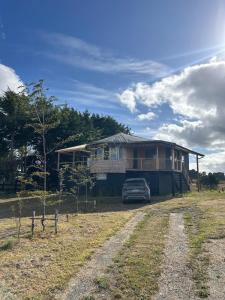 a house with a car parked in front of it at Refugio con Vista al Mar y Paz in Vilupulli