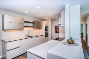 une cuisine avec des armoires blanches et un comptoir dans l'établissement Top Floor Oceanfront Condo, à San Diego