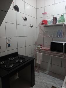 a kitchen with a stove and a counter top at Maranata Suítes in Peruíbe