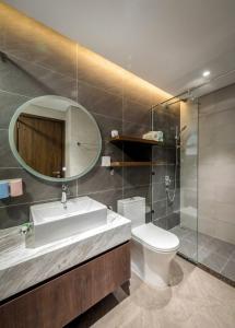 a bathroom with a sink and a toilet and a mirror at FLC Sea Tower Quy Nhơn-Codotel 5 Sao Giáp Biển-Trung Tâm TP Quy Nhơn in Quy Nhon